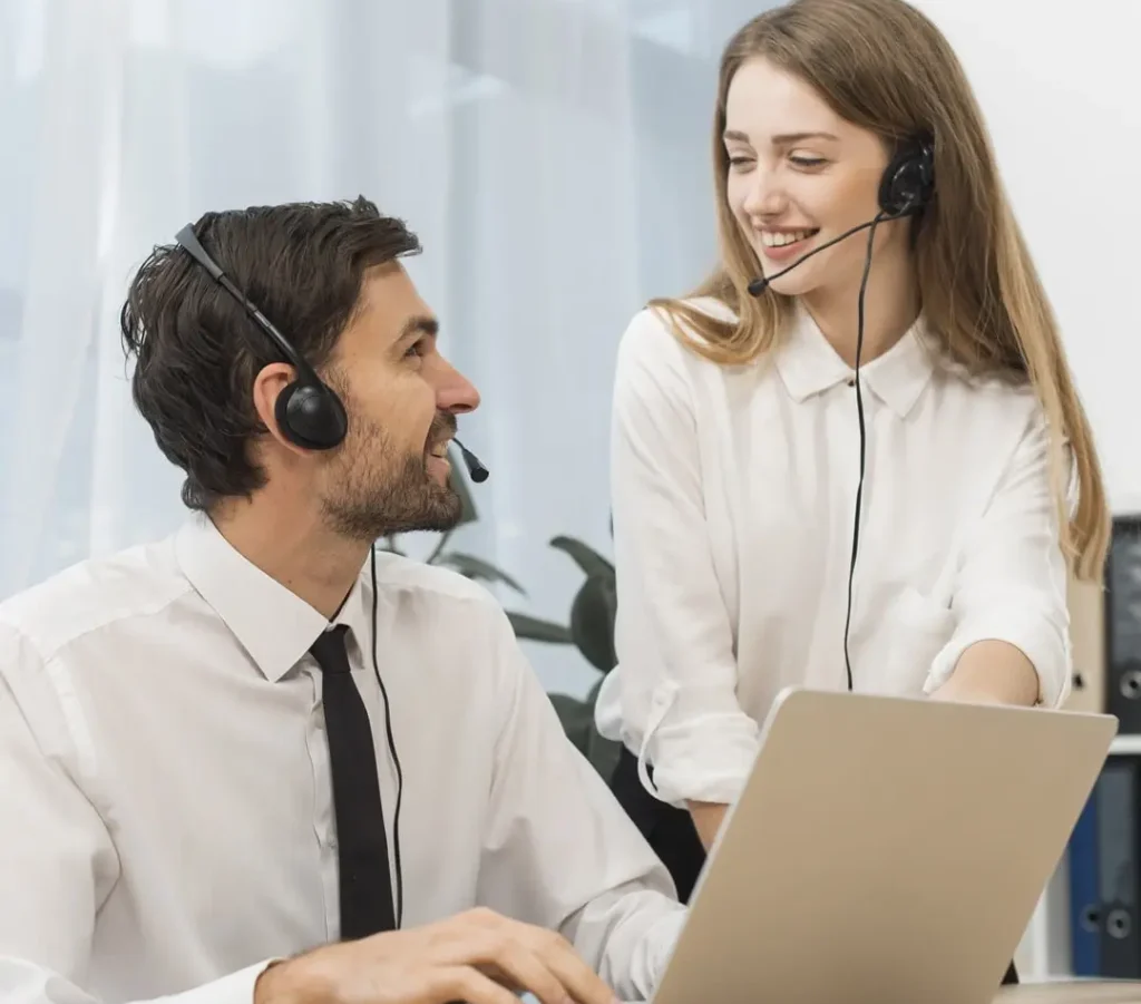 A man and a woman discussing web design services at their desks in an online solutions company